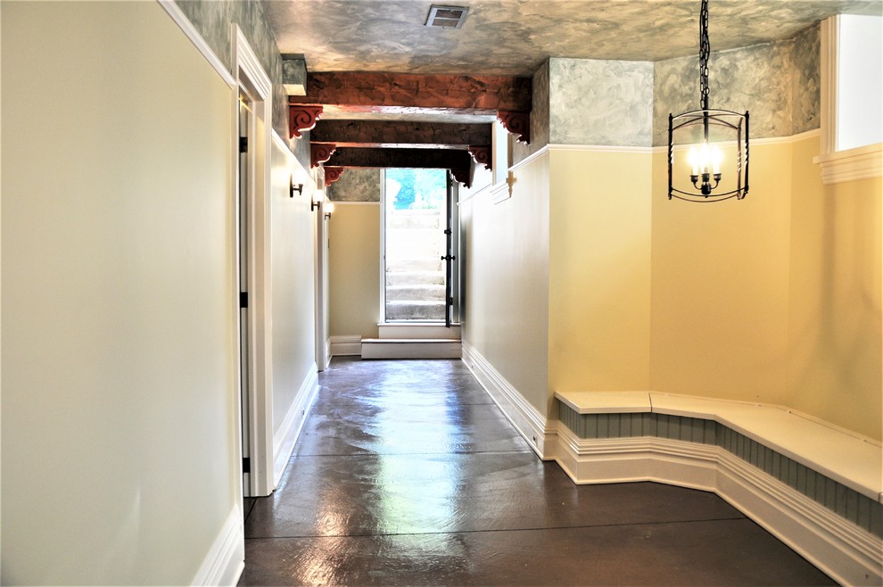 На фото: большой коридор в классическом стиле с разноцветными стенами и бетонным полом
