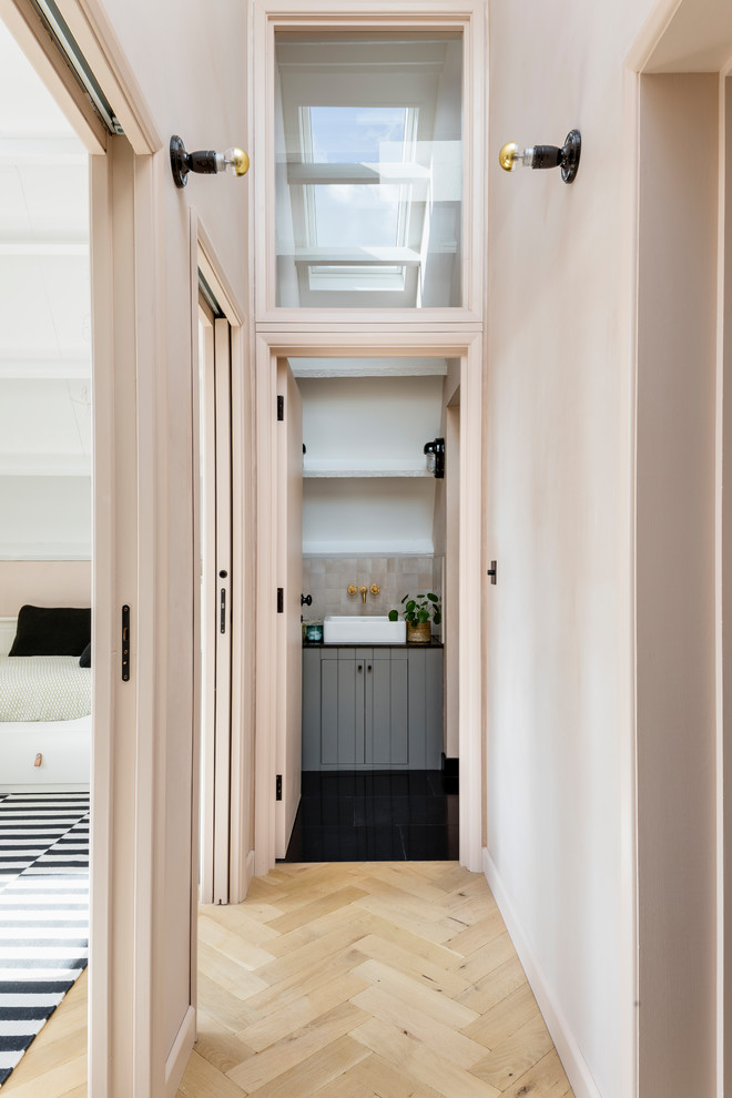 Inspiration for an industrial light wood floor hallway remodel in London with pink walls