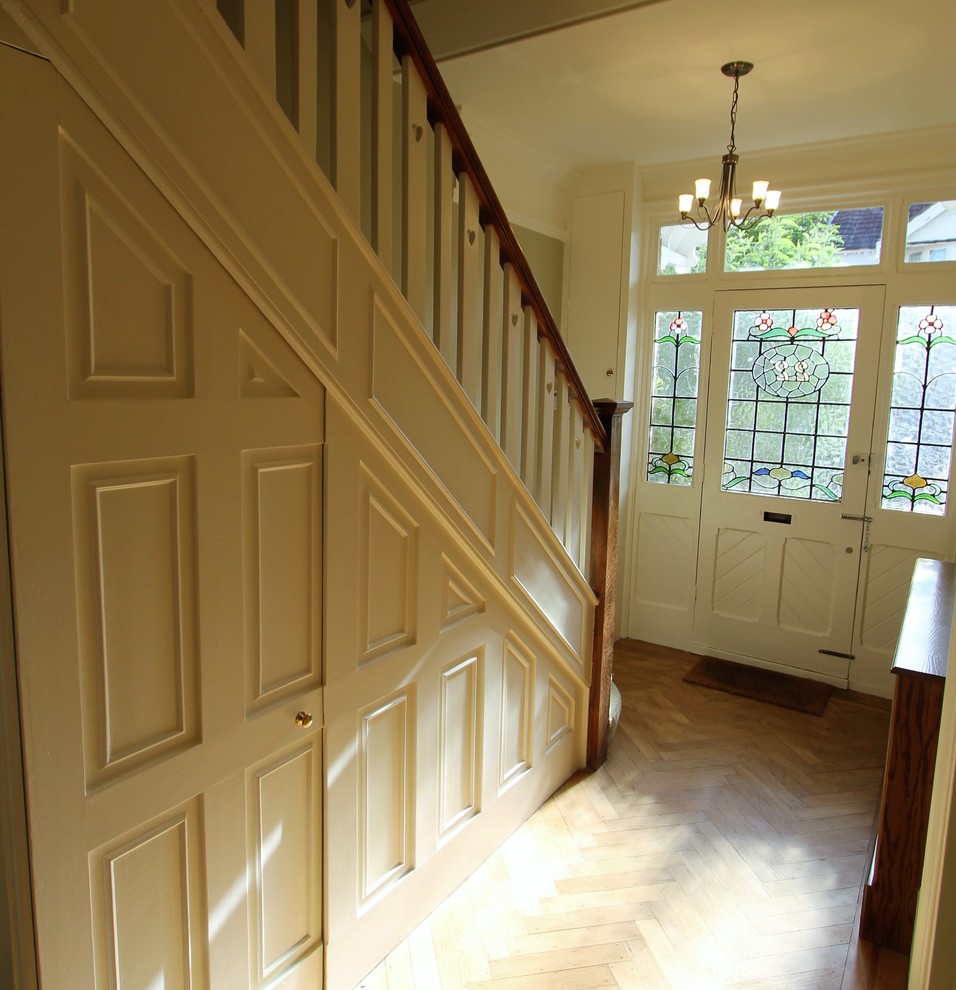 Ejemplo de recibidores y pasillos clásicos pequeños con paredes beige y suelo de madera en tonos medios
