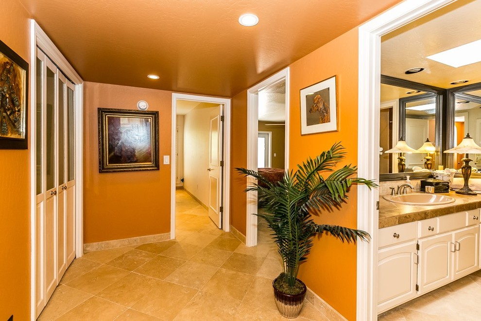 Cette image montre un couloir chalet de taille moyenne avec un mur orange et un sol en marbre.