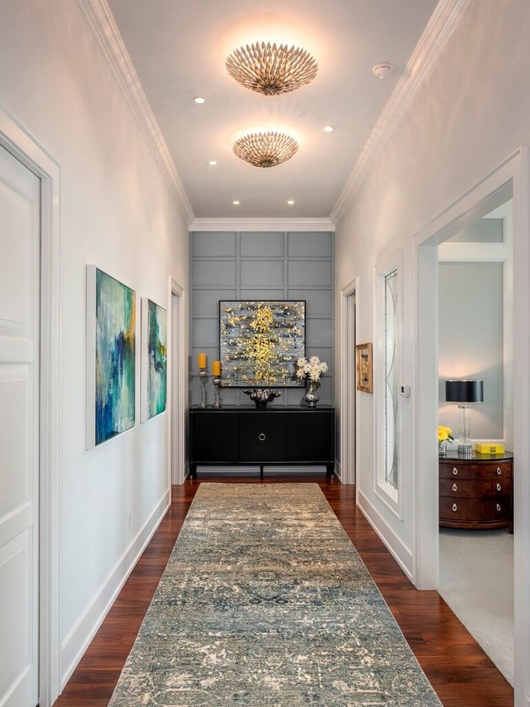 Large transitional medium tone wood floor hallway photo in Miami with white walls