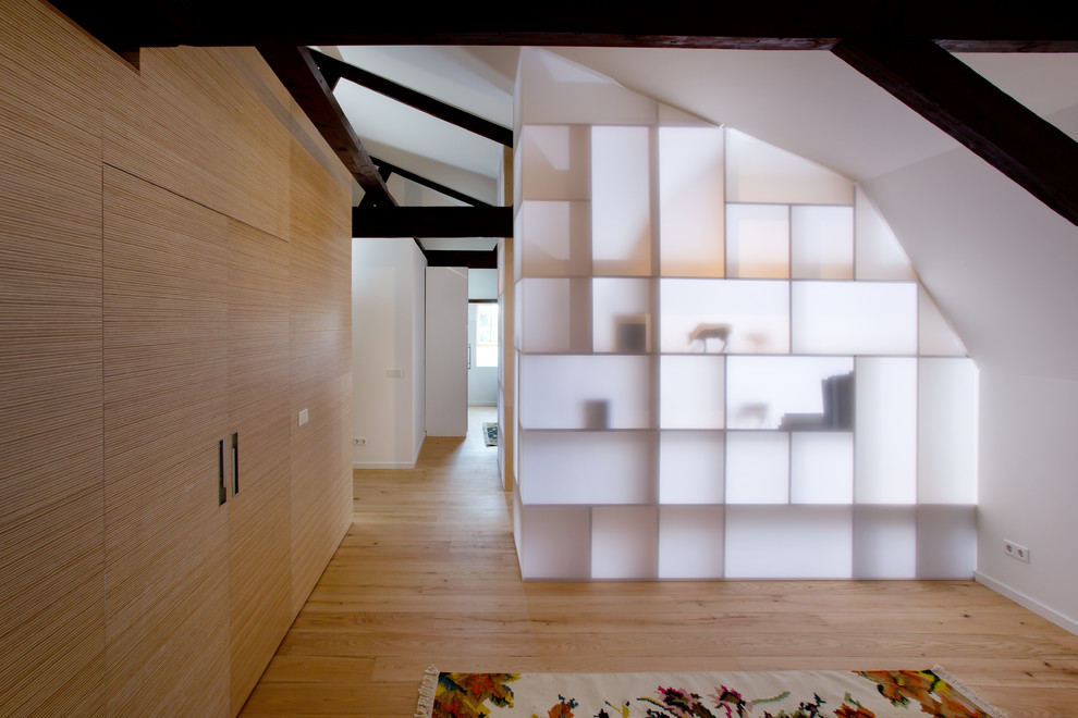Foto de recibidores y pasillos modernos con paredes blancas y suelo de madera en tonos medios