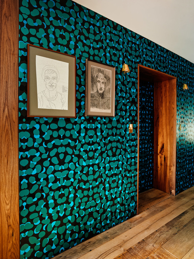 Réalisation d'un couloir design avec un sol en bois brun et un mur multicolore.