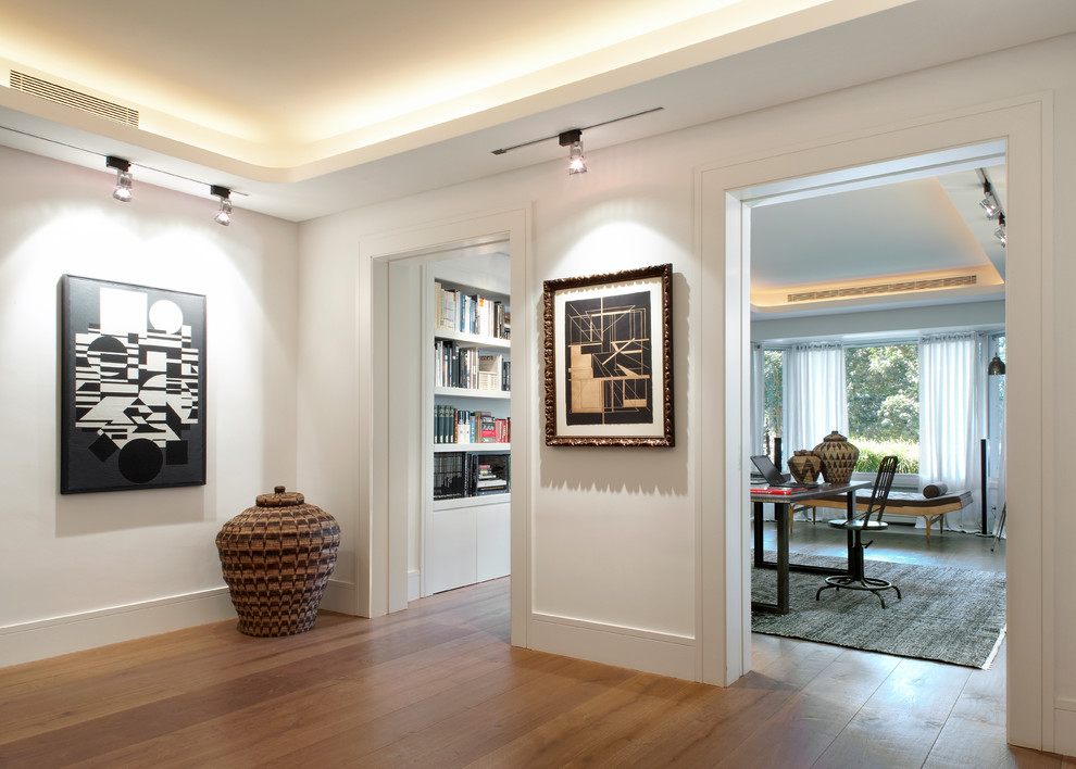 Esempio di un ingresso o corridoio minimal di medie dimensioni con pareti bianche e pavimento in legno massello medio
