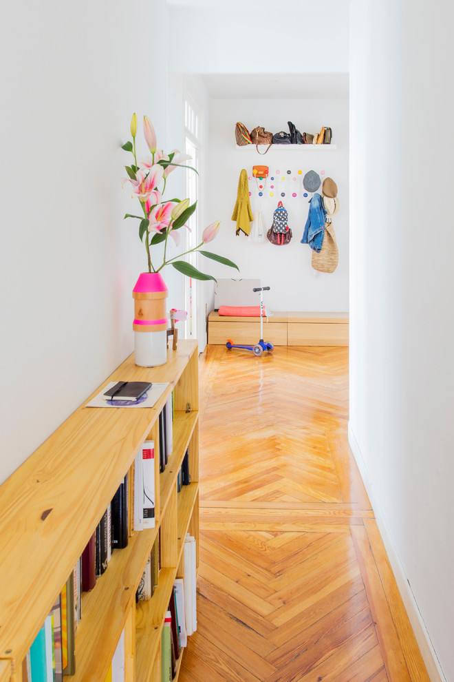 Idées déco pour un petit couloir scandinave avec un mur blanc et un sol en bois brun.