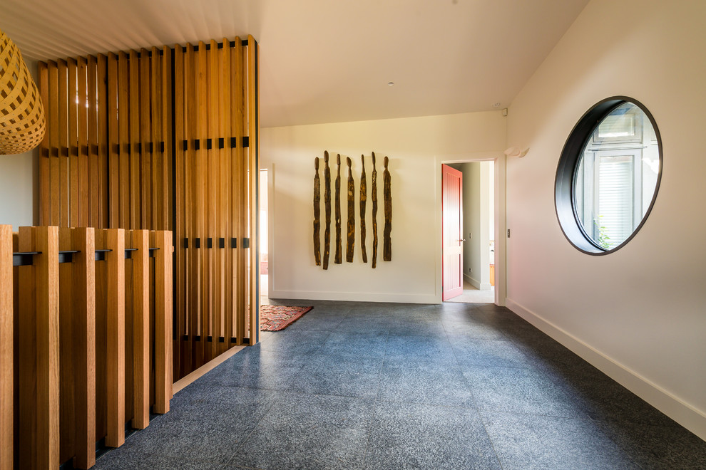 Hallway - mid-sized contemporary gray floor and linoleum floor hallway idea in Auckland with white walls