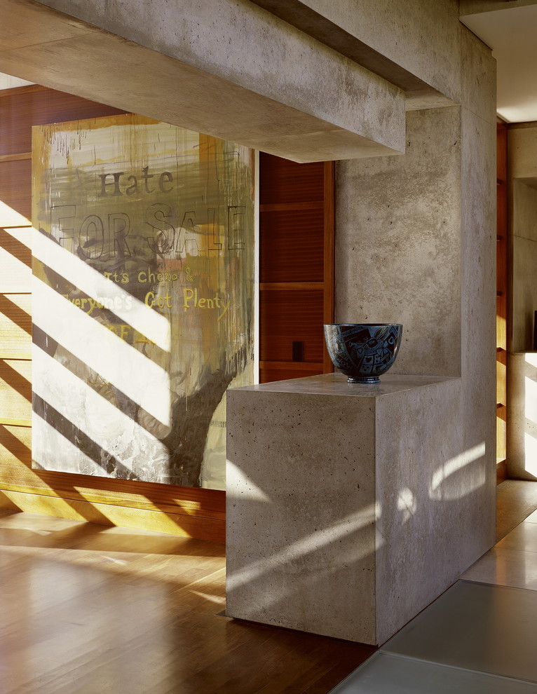 Idée de décoration pour un couloir design avec un sol en bois brun.