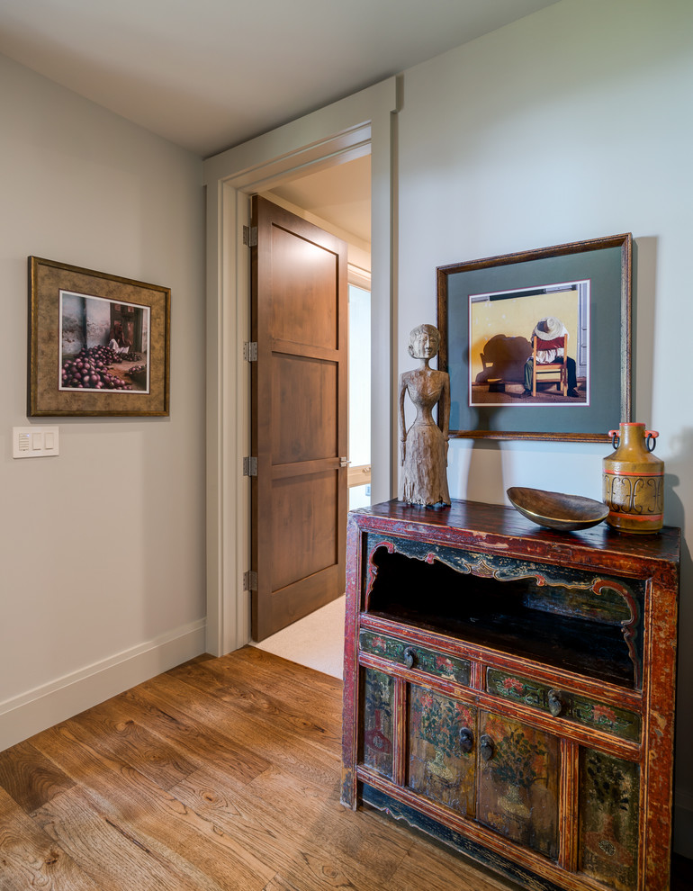 Example of a large transitional medium tone wood floor hallway design in Other with beige walls