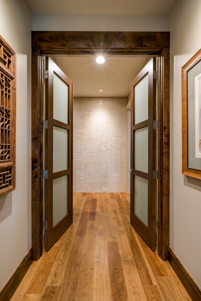Inspiration pour un grand couloir traditionnel avec un mur beige et un sol en bois brun.