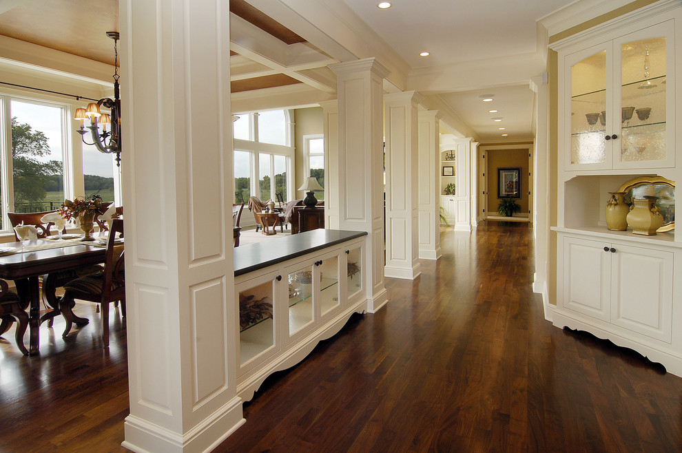 Стильный дизайн: коридор в классическом стиле с белыми стенами, темным паркетным полом и коричневым полом - последний тренд