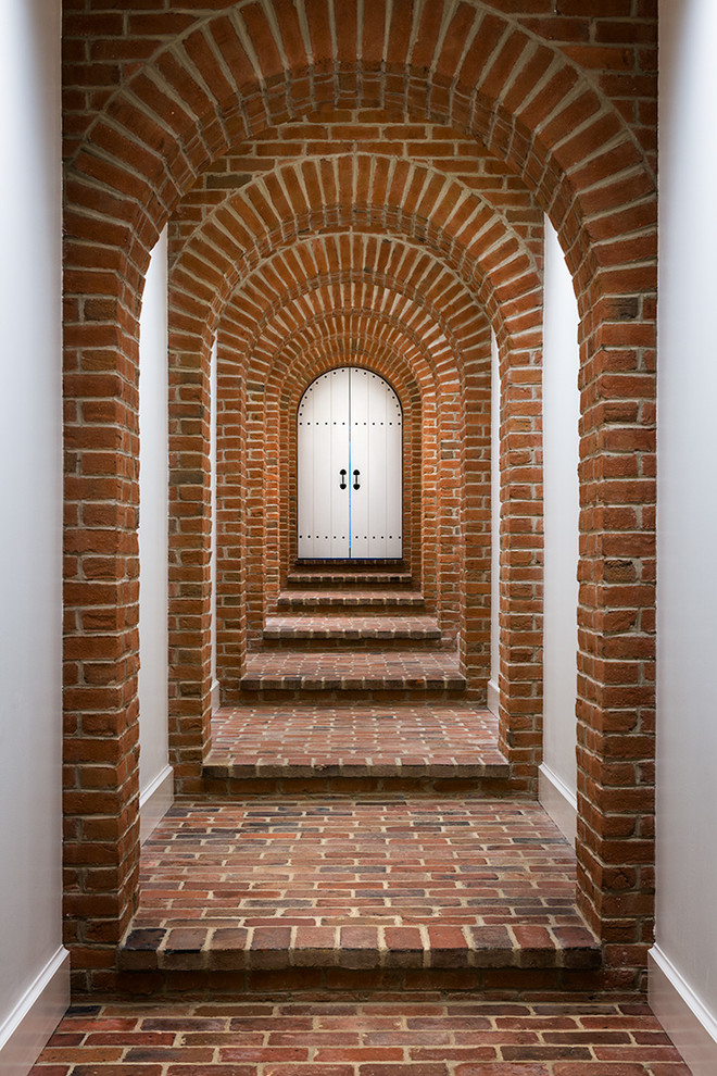 Immagine di un ingresso o corridoio tradizionale con pareti bianche e pavimento in mattoni