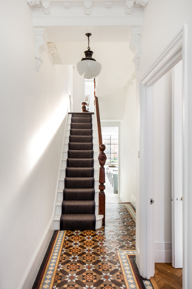 Example of a large transitional terra-cotta tile hallway design in London with white walls