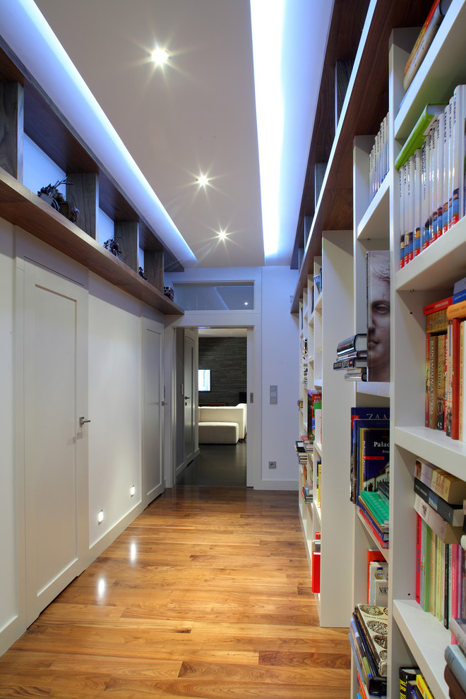 Idee per un ingresso o corridoio minimal con pareti bianche e pavimento in legno massello medio