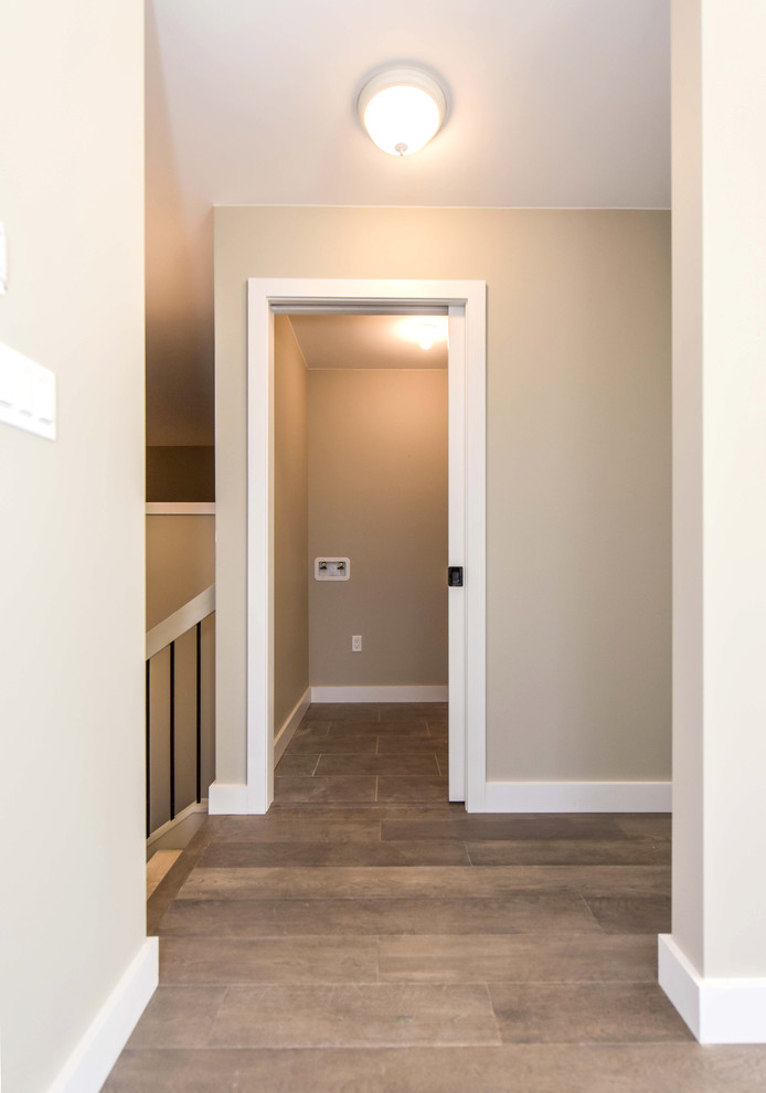 Esempio di un ingresso o corridoio minimal di medie dimensioni con pareti beige, pavimento in legno massello medio e pavimento marrone