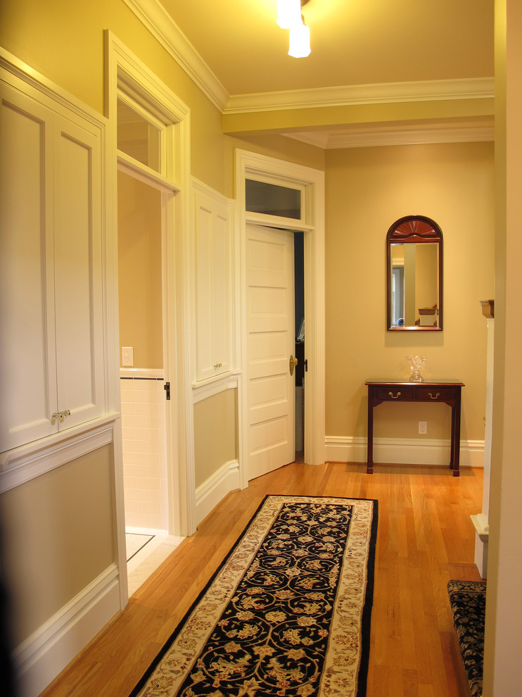 Foto de recibidores y pasillos clásicos grandes con paredes beige y suelo de madera en tonos medios