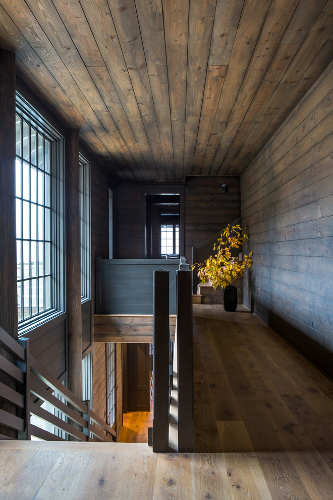 Elegant medium tone wood floor and brown floor hallway photo in Nashville with brown walls