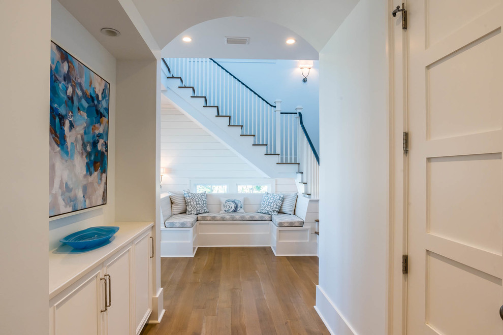 Geräumiger Shabby-Style Flur mit weißer Wandfarbe, hellem Holzboden und braunem Boden in Sonstige