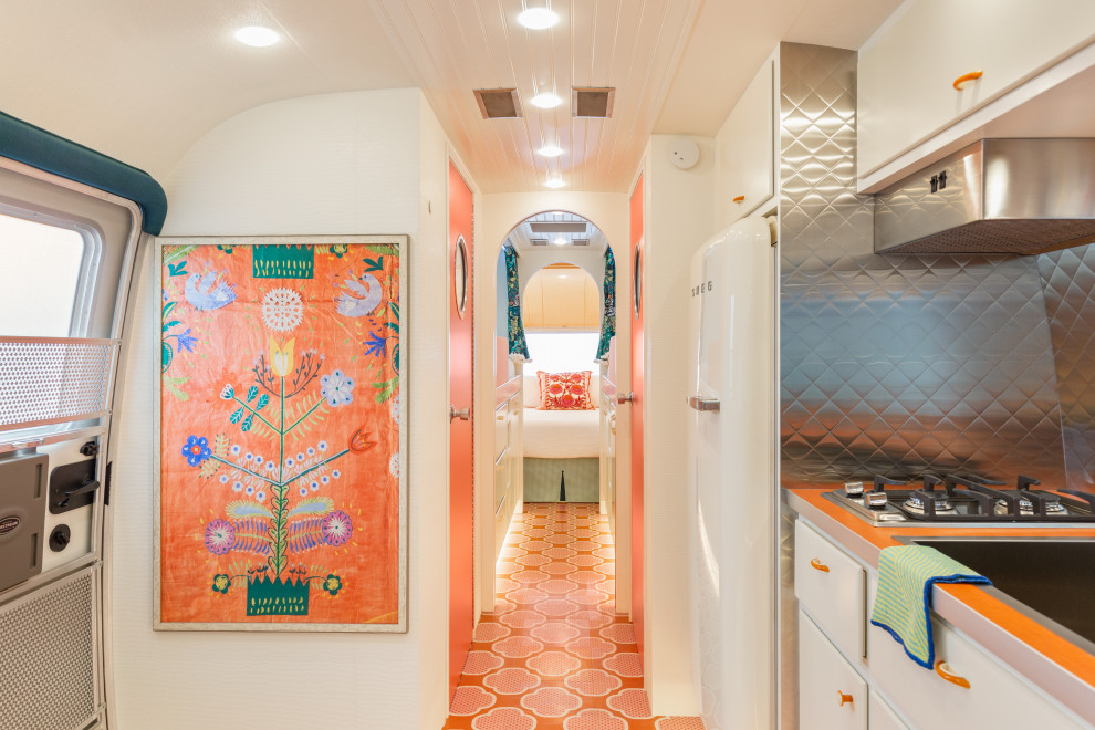 Foto di un piccolo ingresso o corridoio bohémian con pareti bianche, pavimento in legno verniciato e pavimento arancione