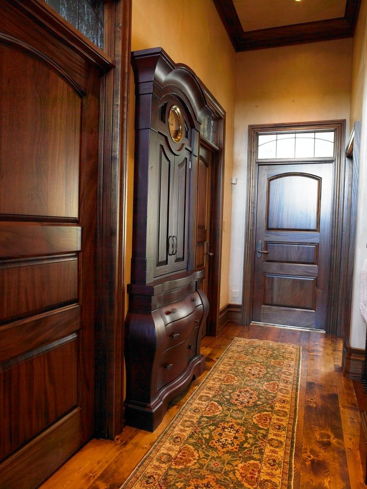 Modelo de recibidores y pasillos clásicos renovados grandes con paredes beige y suelo de madera en tonos medios