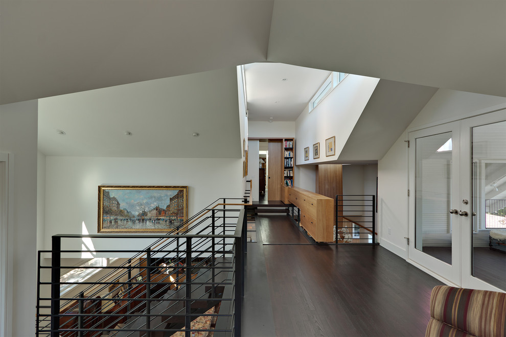Photo of a contemporary hallway in Austin with white walls, dark hardwood floors and brown floor.