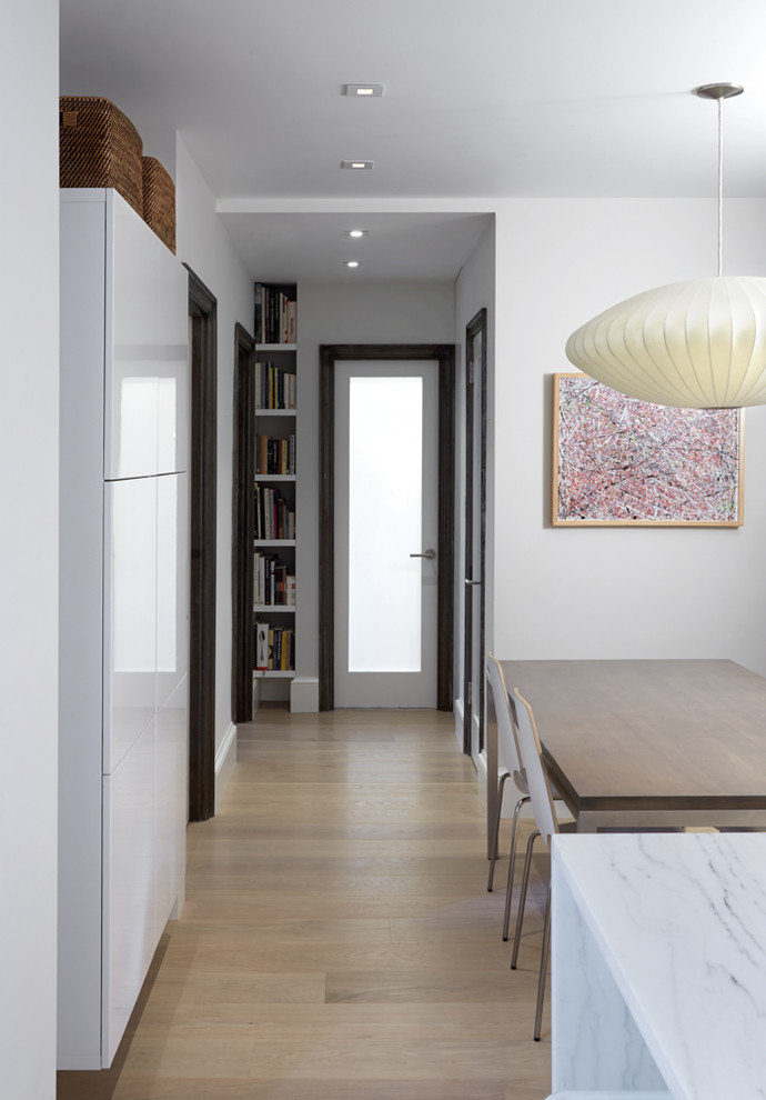Idée de décoration pour un petit couloir design avec un mur blanc, parquet clair et un sol beige.