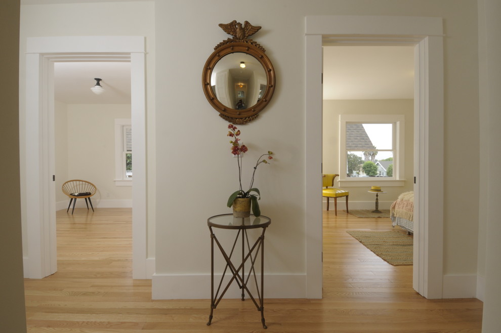 Large arts and crafts light wood floor hallway photo in Los Angeles with white walls