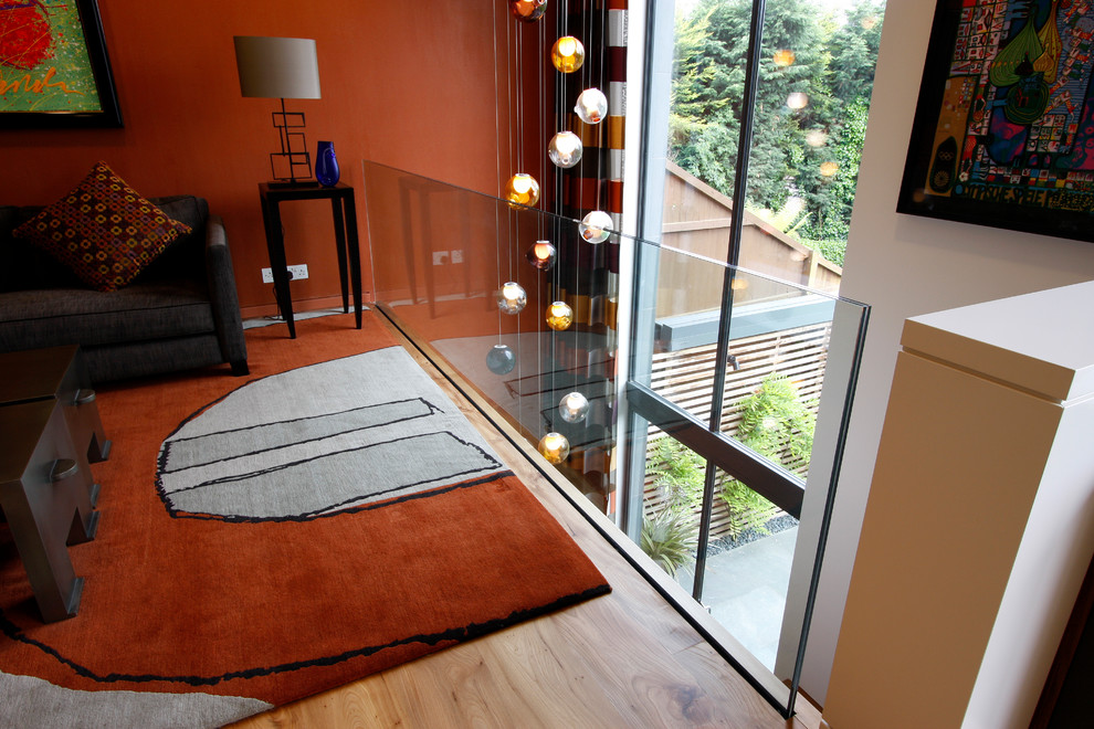 Modelo de recibidores y pasillos modernos con parades naranjas, suelo de madera en tonos medios, suelo marrón y iluminación