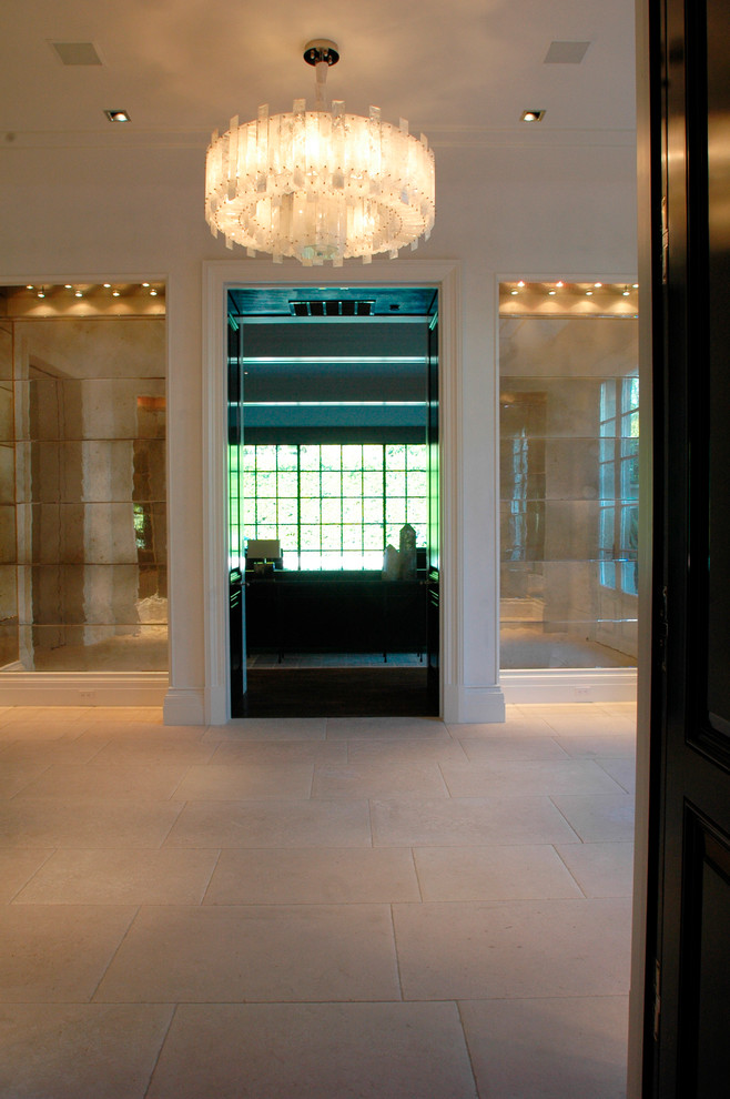 Свежая идея для дизайна: огромный коридор в стиле неоклассика (современная классика) с бежевыми стенами и полом из известняка - отличное фото интерьера