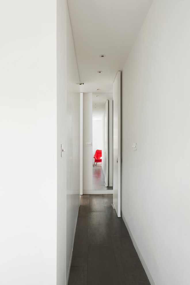 Cette photo montre un petit couloir nature avec un mur blanc et sol en béton ciré.
