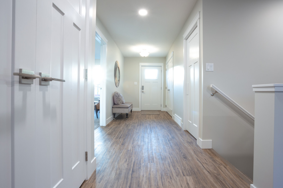 На фото: коридор среднего размера в стиле кантри с бежевыми стенами, полом из винила и коричневым полом