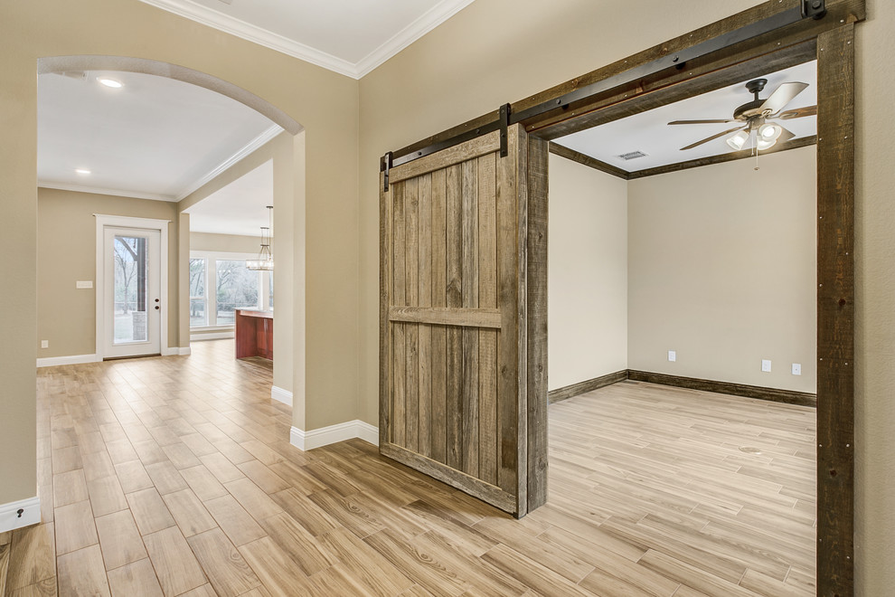 Example of a farmhouse medium tone wood floor and beige floor hallway design in Dallas with beige walls