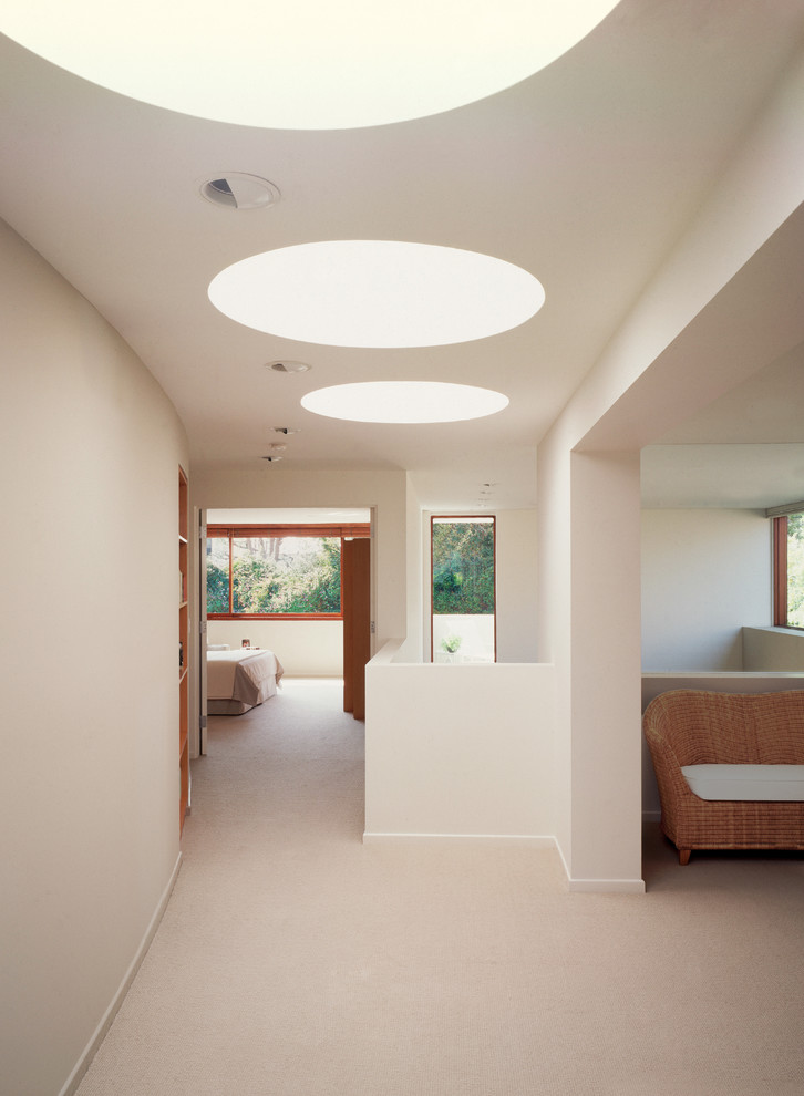 Foto de recibidores y pasillos minimalistas grandes con paredes beige y moqueta