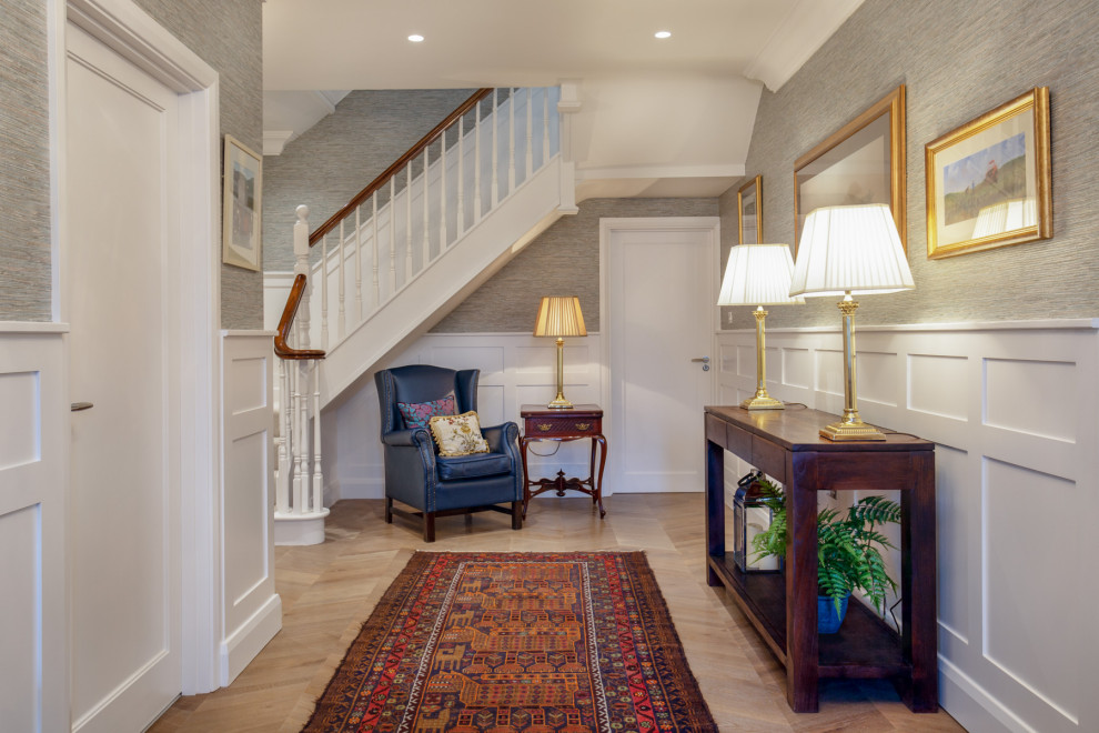 Example of a large classic dark wood floor, brown floor and wainscoting hallway design in Other with gray walls