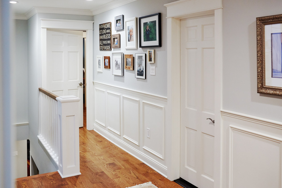 Modelo de recibidores y pasillos tradicionales renovados de tamaño medio con paredes blancas y suelo de madera en tonos medios