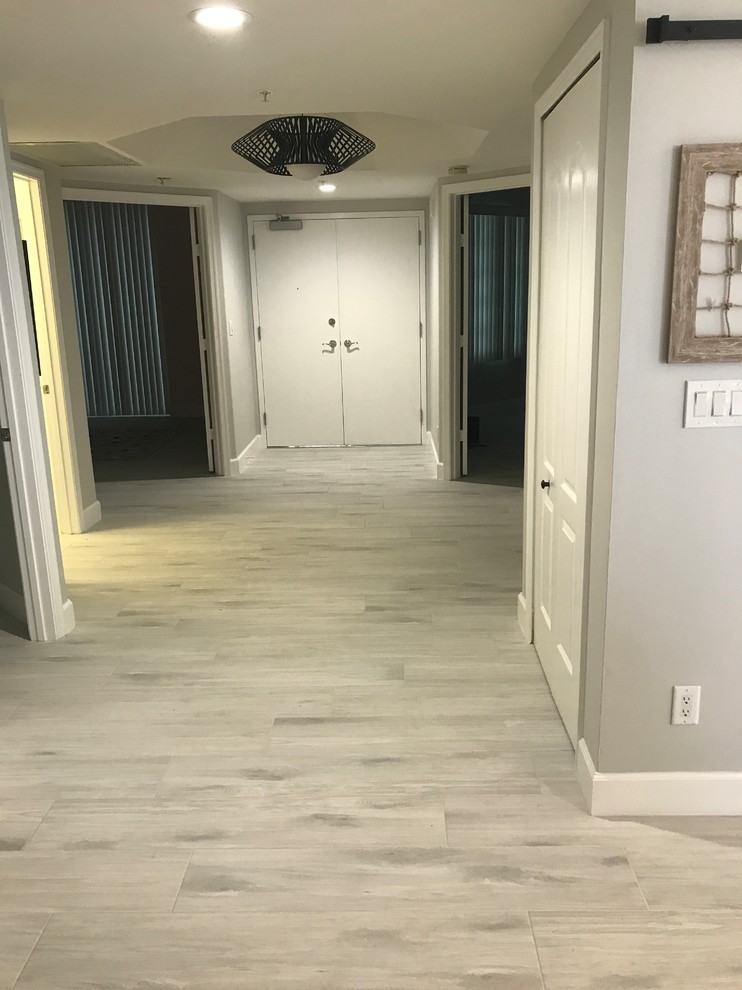 Hallway - large contemporary porcelain tile and gray floor hallway idea in Miami with gray walls