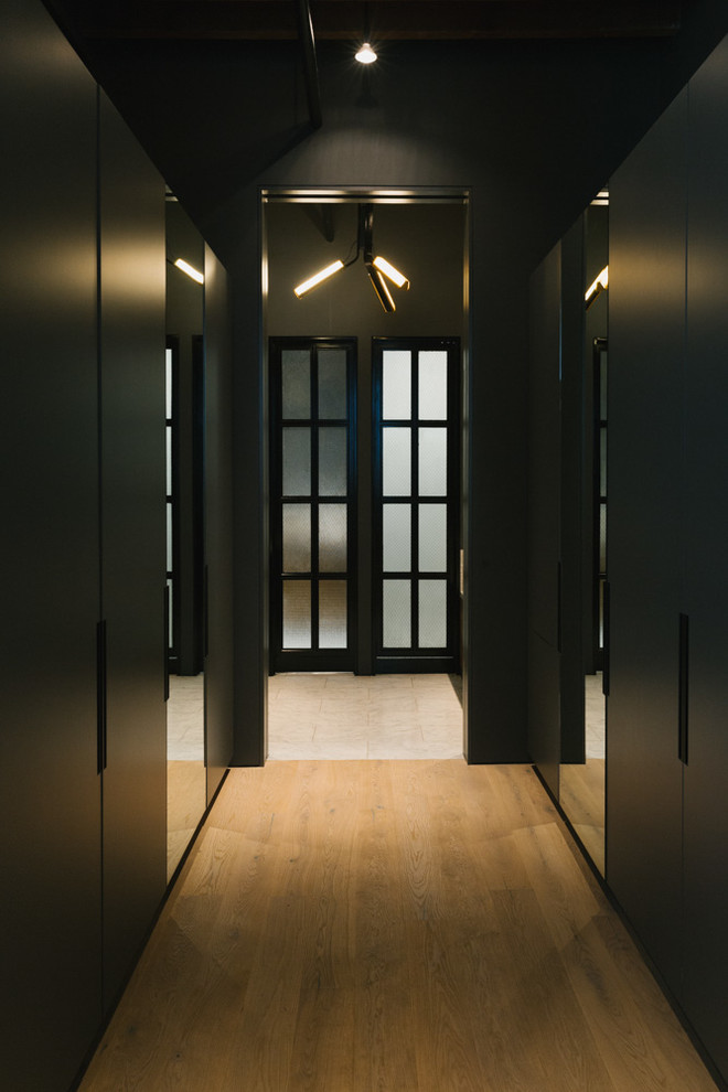 Hallway - mid-sized contemporary light wood floor hallway idea in New York with black walls