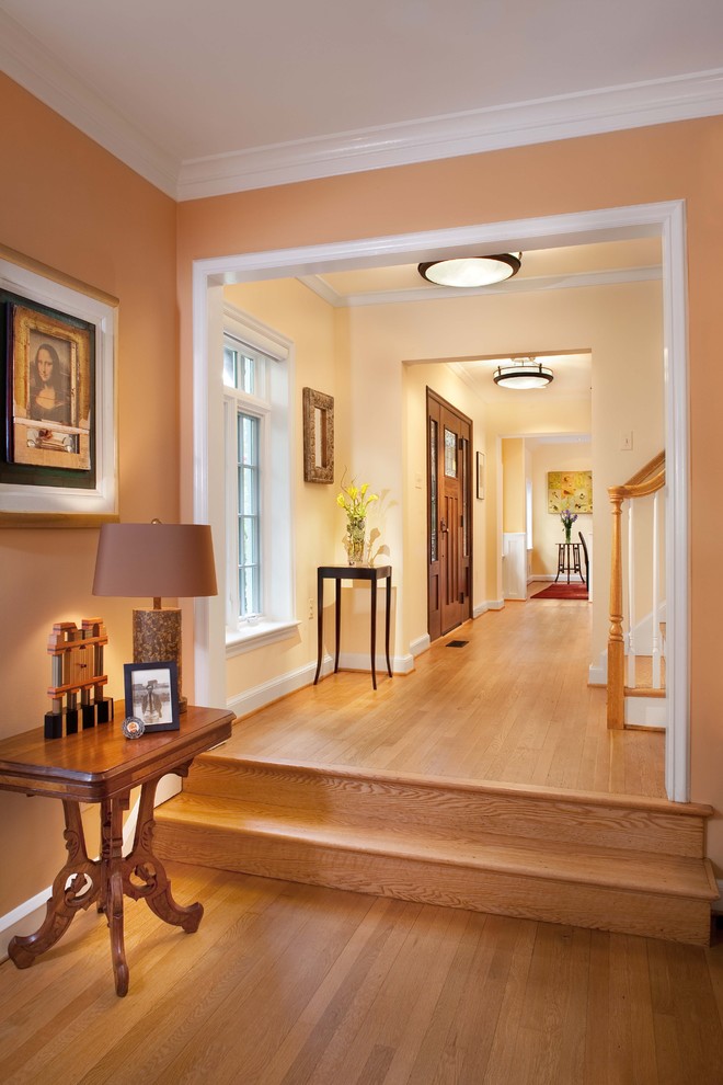 На фото: коридор: освещение в классическом стиле с оранжевыми стенами и паркетным полом среднего тона с