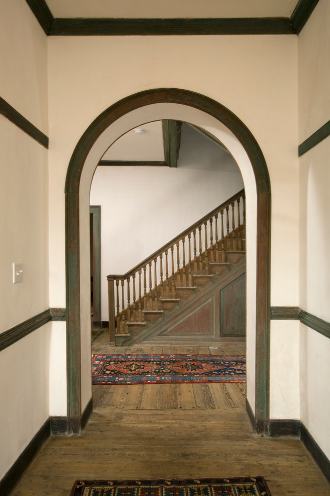 Ispirazione per un ingresso o corridoio country di medie dimensioni con pareti bianche e pavimento in legno massello medio