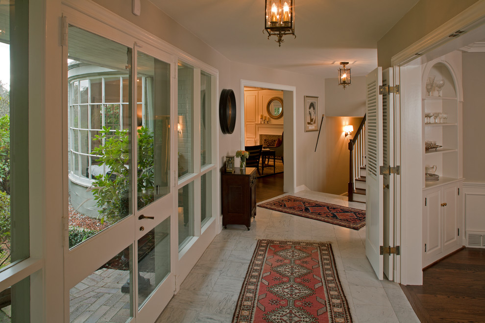 Foto de recibidores y pasillos tradicionales de tamaño medio con paredes beige, suelo de mármol y suelo blanco