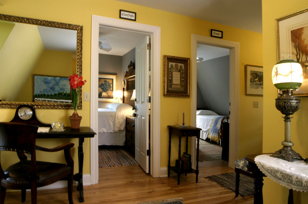 Modelo de recibidores y pasillos tradicionales de tamaño medio con paredes amarillas y suelo de madera en tonos medios