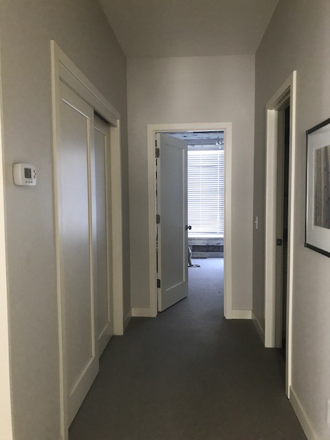 ミネアポリスにある中くらいなカントリー風のおしゃれな廊下 (白い壁、カーペット敷き、グレーの床) の写真