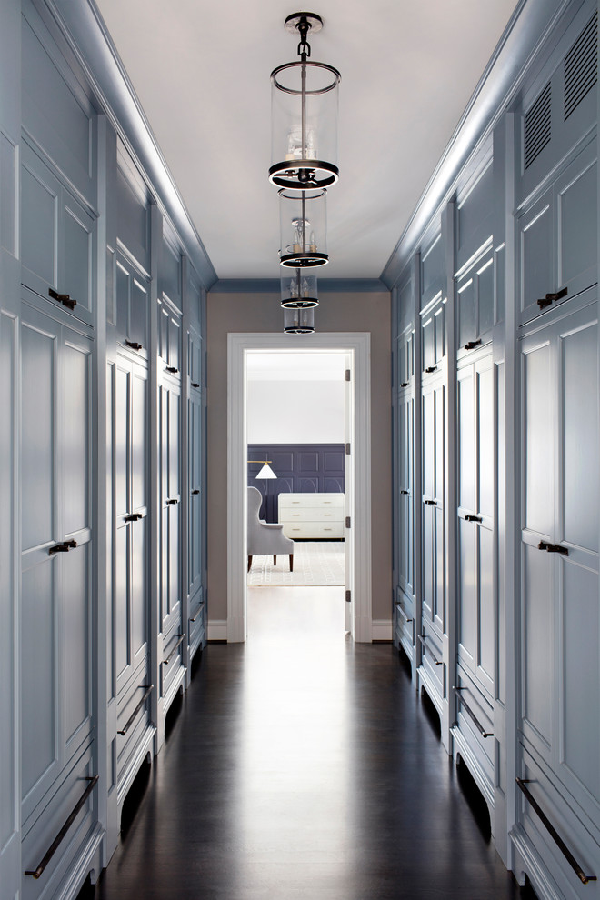 Cette image montre un grand couloir traditionnel avec un mur gris et parquet foncé.