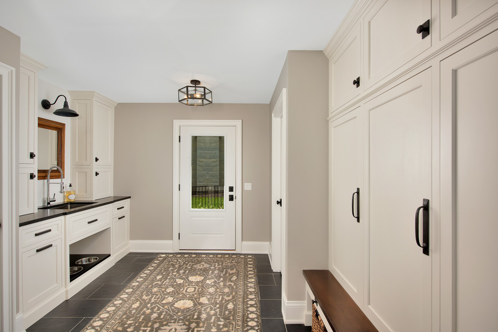 Example of a mid-sized transitional laminate floor and black floor hallway design in Chicago with beige walls