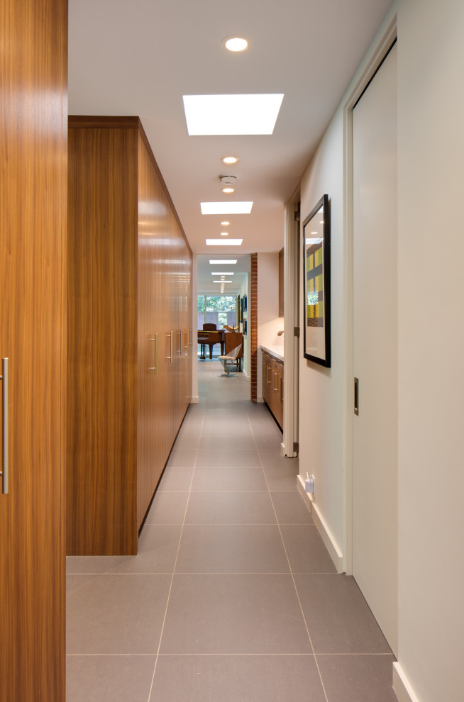 Esempio di un grande ingresso o corridoio moderno con pareti bianche, pavimento in gres porcellanato e pavimento grigio