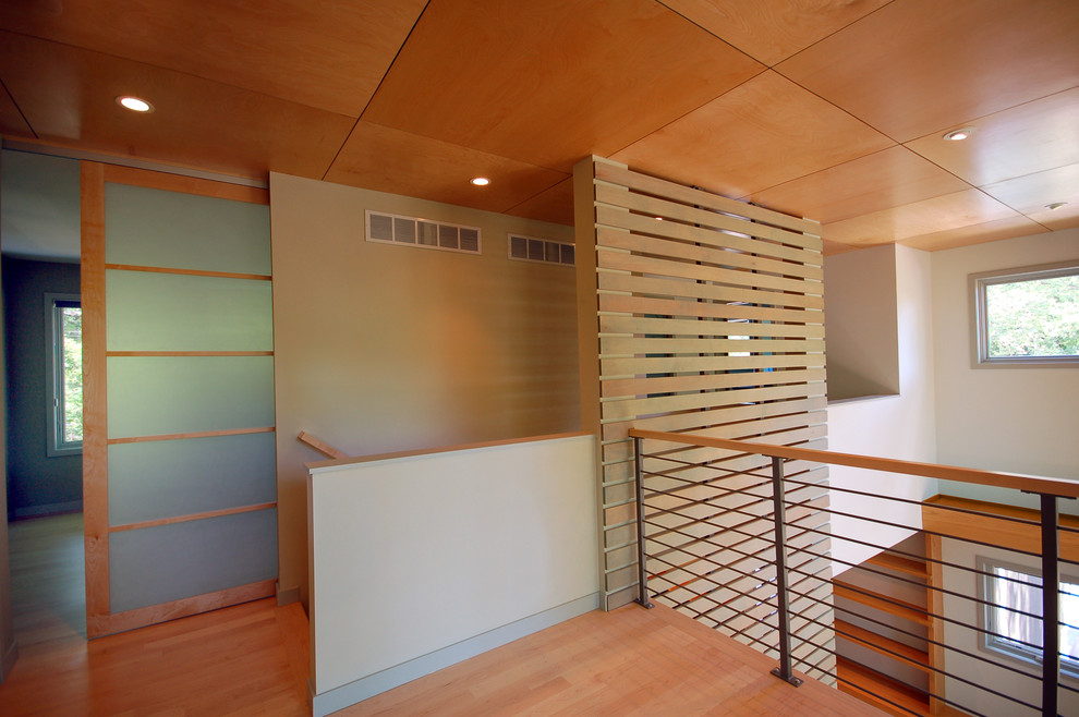 Example of a minimalist medium tone wood floor hallway design in Minneapolis with white walls