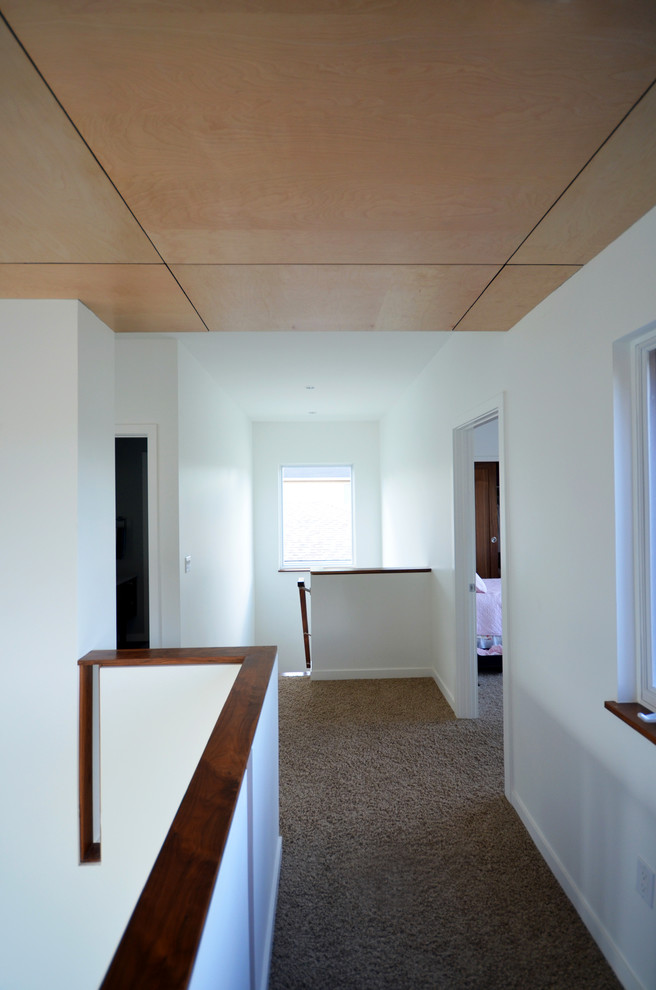 На фото: коридор в стиле модернизм с белыми стенами и ковровым покрытием с