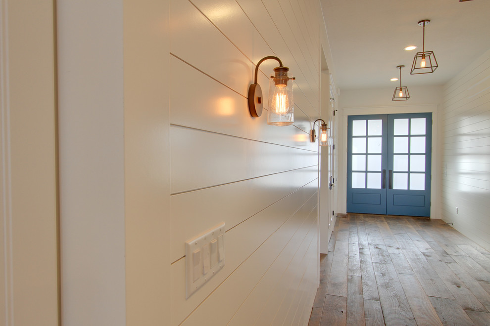 Idée de décoration pour un grand couloir champêtre avec un mur blanc et parquet clair.