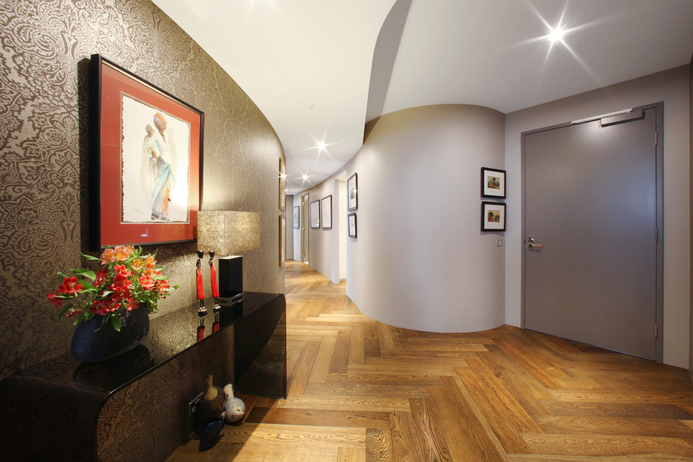 Idée de décoration pour un couloir design avec un mur blanc, un sol en bois brun et un sol jaune.