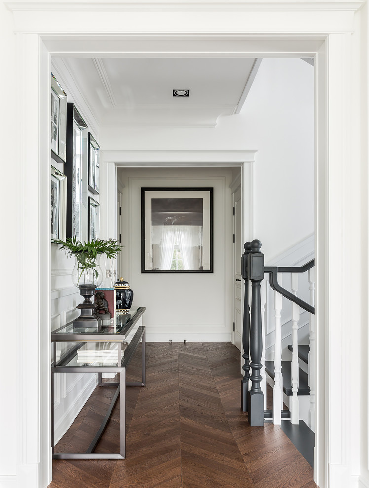Свежая идея для дизайна: коридор в стиле неоклассика (современная классика) с белыми стенами, темным паркетным полом и коричневым полом - отличное фото интерьера