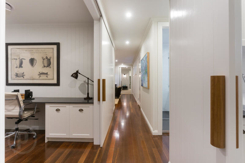Inspiration pour un couloir minimaliste de taille moyenne avec un mur blanc et un sol en bois brun.